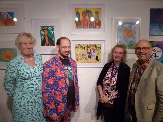 From left: Jackie Coulson (mum), Olly Coulson (artist), Ginny Boxall (Alton deputy town mayor) and John Coulson (dad) at private viewing of Through Olly’s Eyes art exhibition at the Allen Gallery in Alton on February 4, 2022. Picture they are standing next to is called The Happy Knitters.