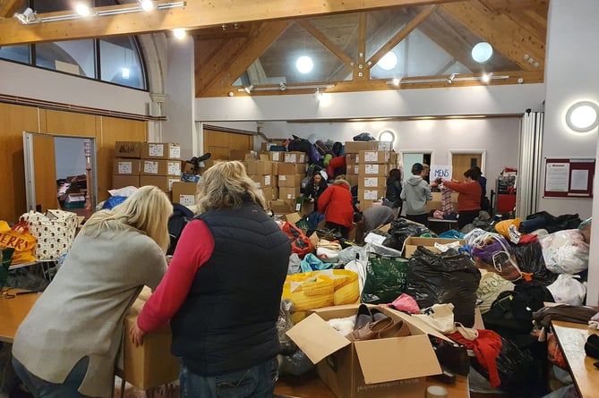 Masses of Farnham Help for Refugees volunteers rolled up their sleeves to help sort the mountain of donations at St George’s Church on March 11