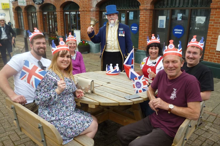 Alton town crier Dave Parsons with, from left, Matt Jordan, Grace Dodd, Tina Rice-Smith, Janet Dodd, Philip Dodd and Christopher Dodd. Market Square, Alton, June 2nd 2022.