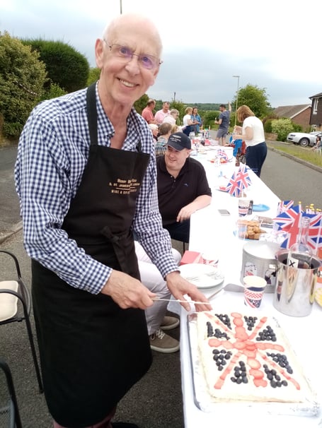 Resident Tony prepares to cut his Platinum Jubilee pavlova at the street party held in Princess Drive, Alton, on June 3rd 2022.