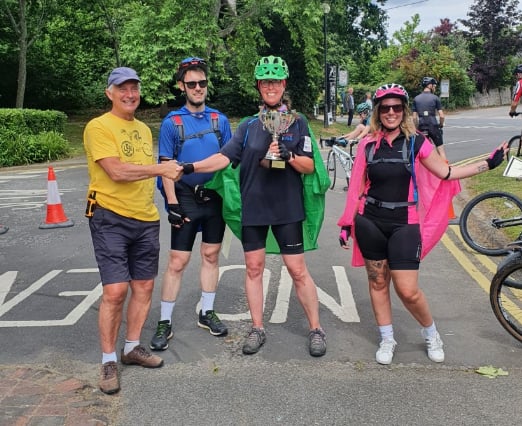 From left: Liphook Bike Ride chairman Alistair Halliday presents the Chairman’s Award for the best dressed riders to Lewis Webb, Jo Mumford and Emma Duffield of Woodlea Primary School in Whitehill on June 12th 2022.