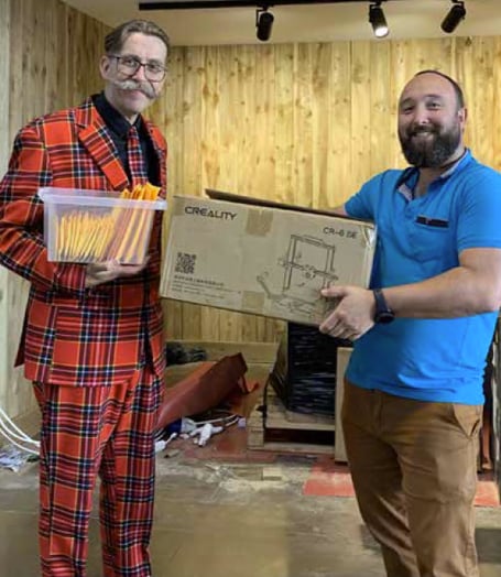 Stuart Morrison, left, gives a 3D printer to Paul Jones.