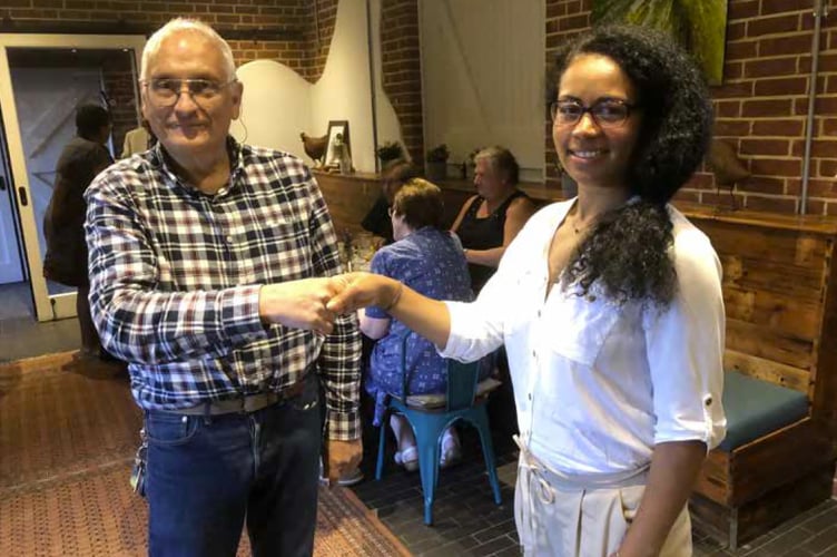 Alton Rotary Club president Mike Sanders welcomes Biola Ameri to the club.