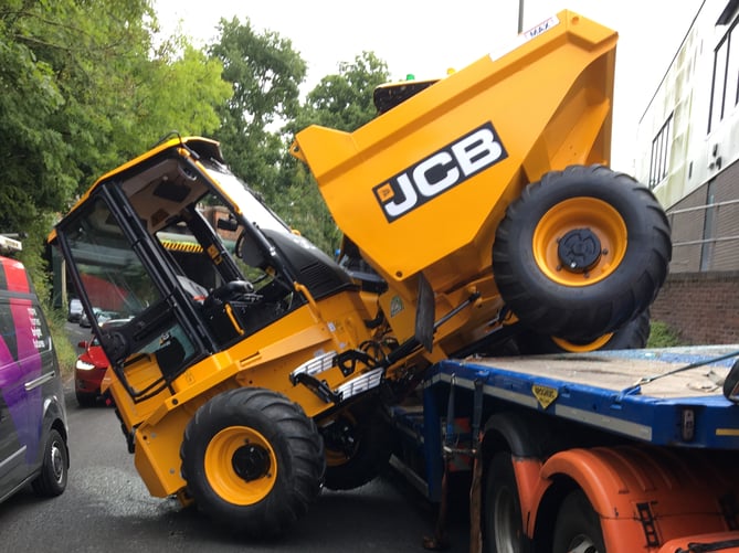 A JCB was knocked off the back of a trailer into incoming traffic after a collision with the A325 Wrecclesham Road railway bridge on Tuesday