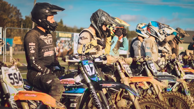 Motocross riders line up at the start line of a race