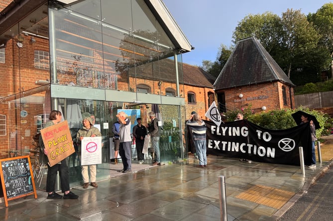 Climate protesters greet attendees of the Farnborough Airport consultation event at the Farnham Maltings