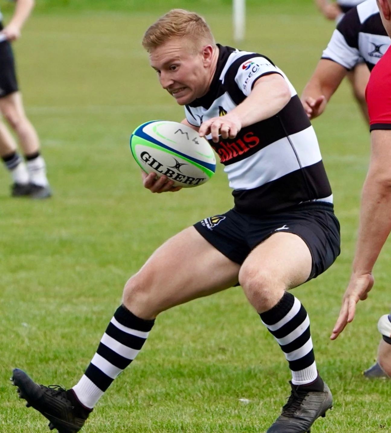 Scrum half Ollie Brown steps away from the Jersey defence