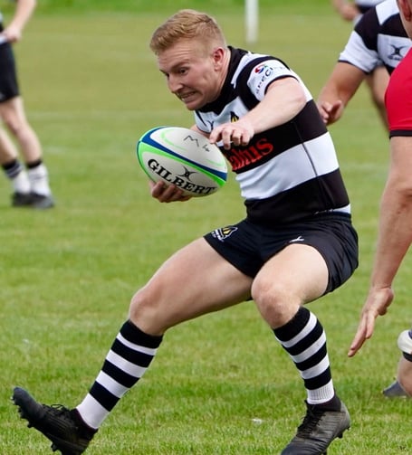 Scrum half Ollie Brown steps away from the Jersey defence