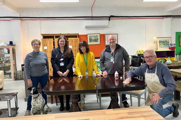 Volunteer Tony works on restoring a table donated to Resurrection Furniture in Alton High Street, November 2023. The dog is Molly.