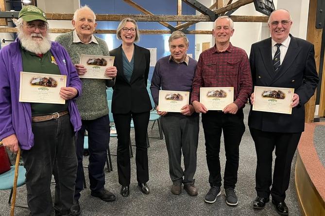 Watercress Line chief executive Rebecca Dalley gives 50-year volunteer certificates to Brian Lawes, Mark Walden, Steve Hayden, Chris le Corney and Jim Russell, February 2024.