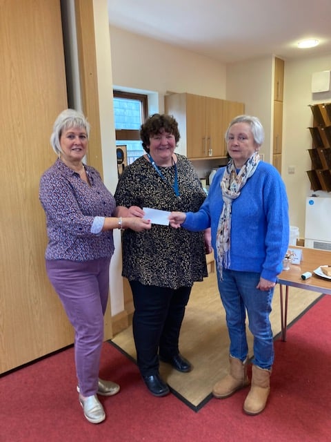 Katie Hughes of Citizens' Advice receives a cheque for £500 from Maureen Mortara and Jane Standing from the Church of St Lawrence, April 2024.