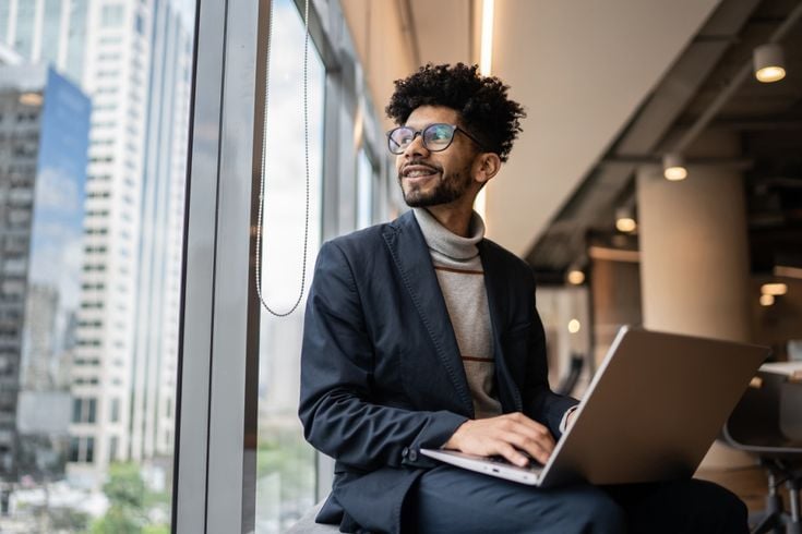 Man looking out of office block window