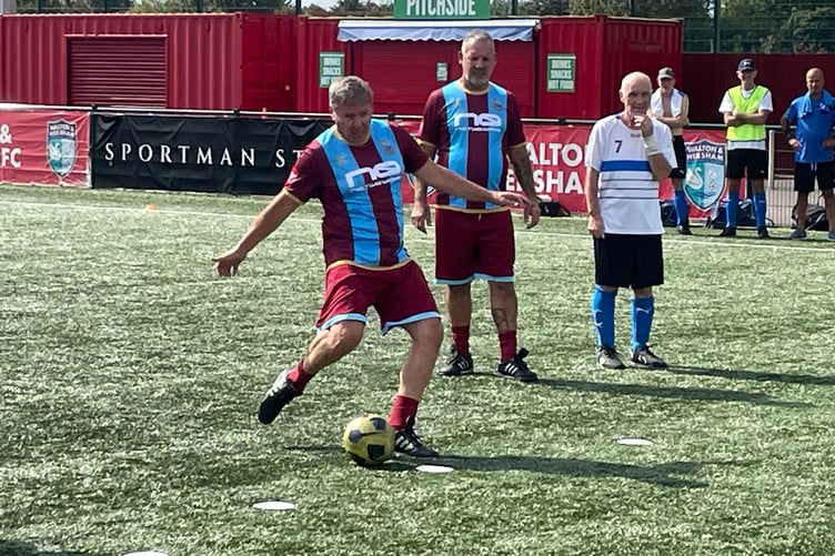 Farnham Town Flares player Mark Clark scores his penalty against Godalming