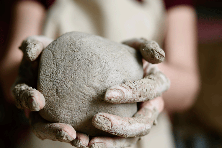 Woman holding clay.