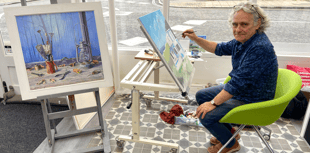 Coastal scene under creation by Tim Burns' paintbrush in Alton gallery