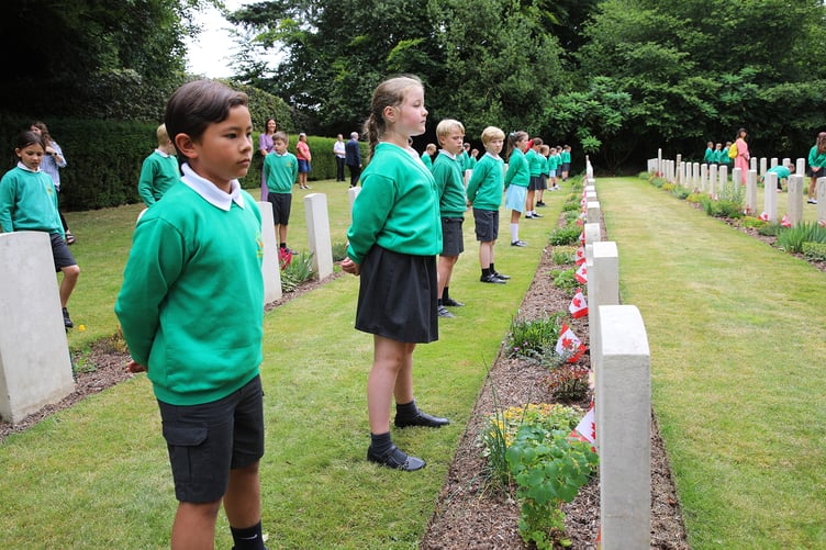Pupils prepare to place a single maple leaf on the grave of the Canadian soldier whose life they have been researching, in the churchyard of St Mary’s, Bramshott.