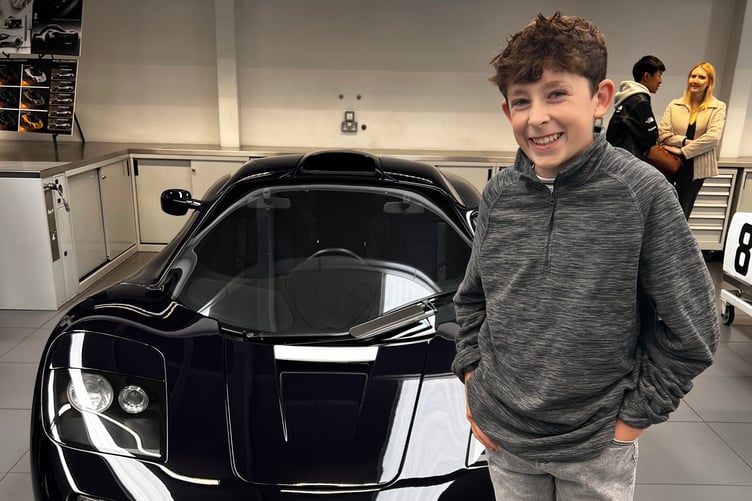 Freddie Child standing in front of a McLaren car at a Lanzante cars open day.