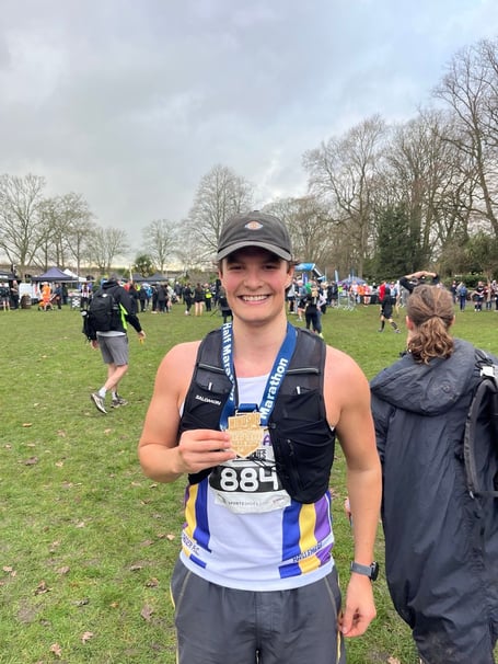 Leon French proudly showing off his Windsor trail half marathon medal