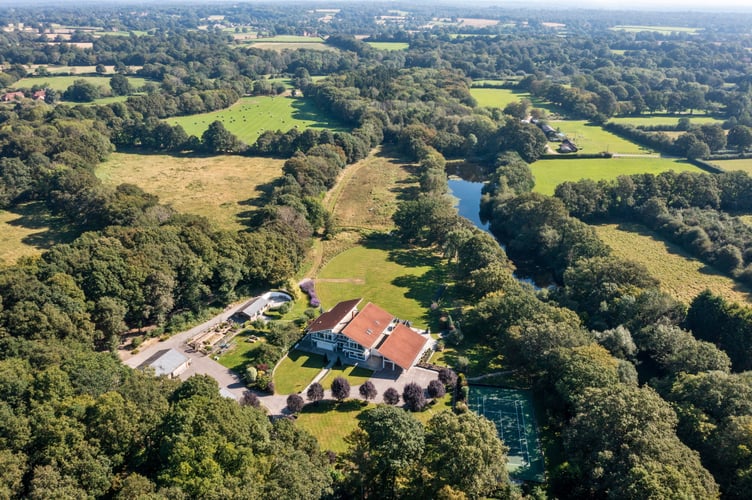 This luxury mansion with an entirely glass exterior is on sale for £4 million- with its own tennis courts and helicopter pad. A five-bedroom house within 20 acres of its own woodland on the Surrey and Sussex border has hit the market which has a striking glass exterior. The gardens of the property in Billingshurst, West Sussex, feature a three-acre lake with rainbow trout, a fishing pontoon, a workshop, a dehumidified multi?car garage, and a cottage. There is also an unrestricted helipad, and an air conditioned storage hanger to keep your helicopter in- which doubles as a golf simulator.