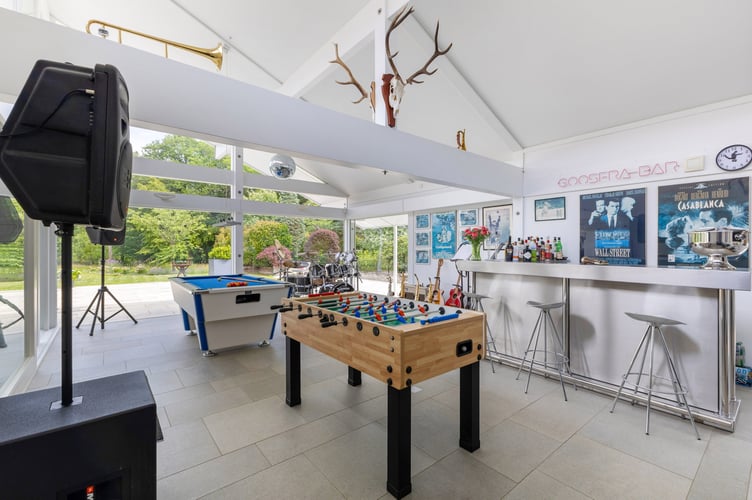 This luxury mansion with an entirely glass exterior is on sale for £4 million- with its own tennis courts and helicopter pad. A five-bedroom house within 20 acres of its own woodland on the Surrey and Sussex border has hit the market which has a striking glass exterior.  The gardens of the property in Billingshurst, West Sussex, feature a three-acre lake with rainbow trout, a fishing pontoon, a workshop, a dehumidified multi?car garage, and a cottage. There is also an unrestricted helipad, and an air conditioned storage hanger to keep your helicopter in- which doubles as a golf simulator. 