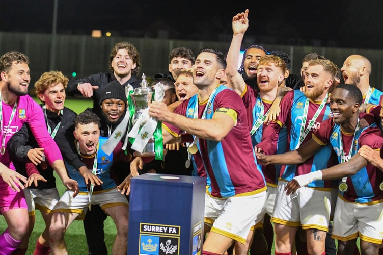 Farnham Town captain Ryan Kinnane lifts the Surrey Senior Cup