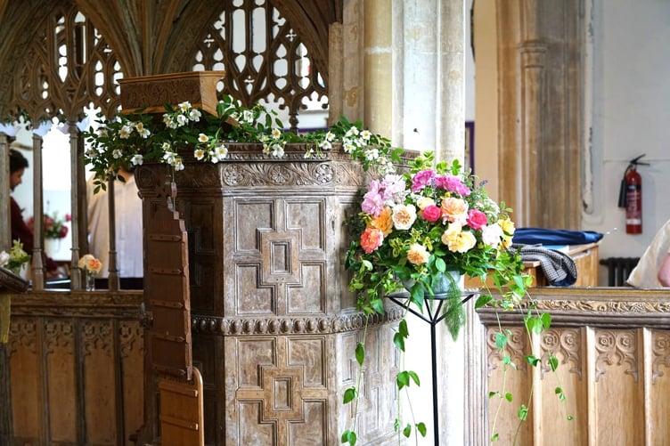 The pulpit adorned with roses in St Petrock's Church, Timberscombe, for Choral Evensong.