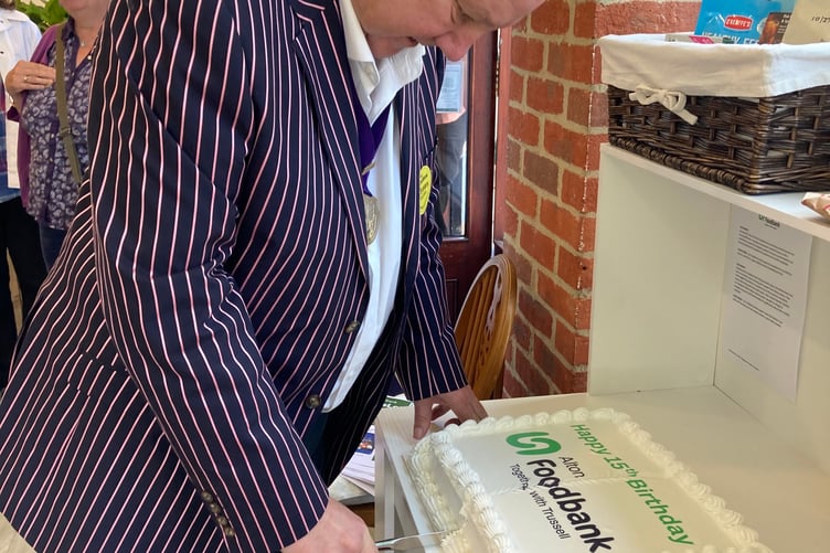 Deputy Alton town mayor Cllr Chris Botten cuts Alton Foodbank's 15th birthday cake, Market Square, Alton, June 13th 2026.