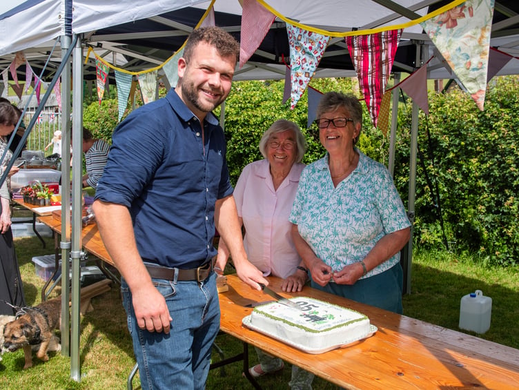 Sam Cowling cuts the Brompton Regis Millennium Green 25th anniversary cake with Babs Page (centre) and Jenny Stringer. PHOTO: Dale Cherry.