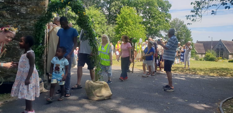 Visitors are blessed by the Rev Colin Simpson as they are led through a willow arch to encircle St John's Church.