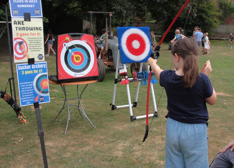 Ava Bowen-Roberts has a go at archery at Roadwater Fete. Photo George Ody.