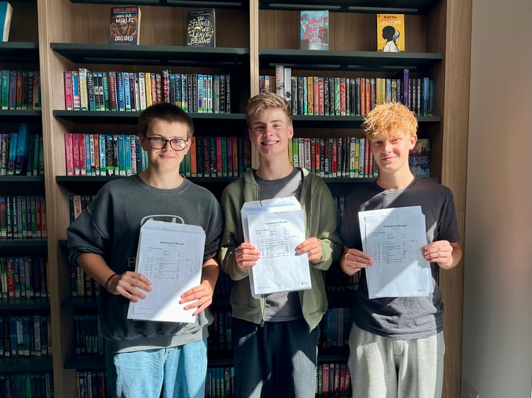 Woolmer Hill pupils celebrate their GCSE results: Stanley Gates, left, Felix Cowan, right, and Callum Yapp, centre.