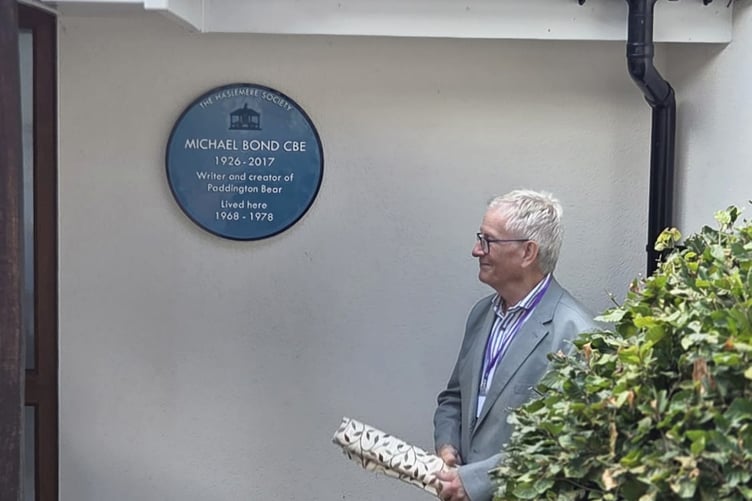 Haslemere Society chairman Chris Harrison stands beside the newly unveiled blue plaque at Michael Bond’s former Haslemere home. Credit: Dawn Brown.