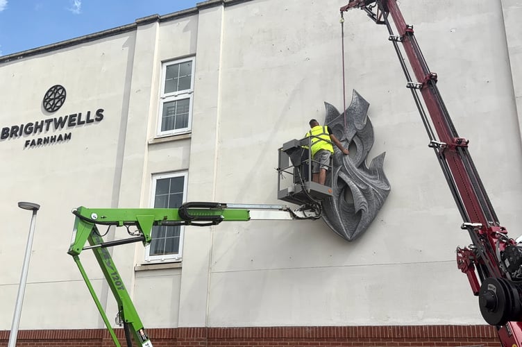 Contractors installing the Farnham Flame on Brightwells in Farnham