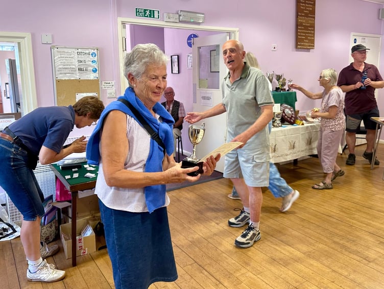 Katy Attwater receiving her cup from Martin Booth for best flower arrangement in Timberscombe Show. PHOTO: Gabrielle Horrobin/Jane Daniels.