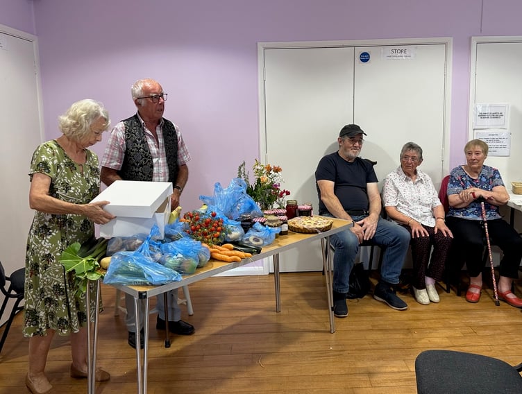 Donated produce on the table ready for the auction, with Joy Booth and auctioneer Ken Powlls, at this year's Timberscombe Show. PHOTO: Gabrielle Horrobin/Jane Daniels.