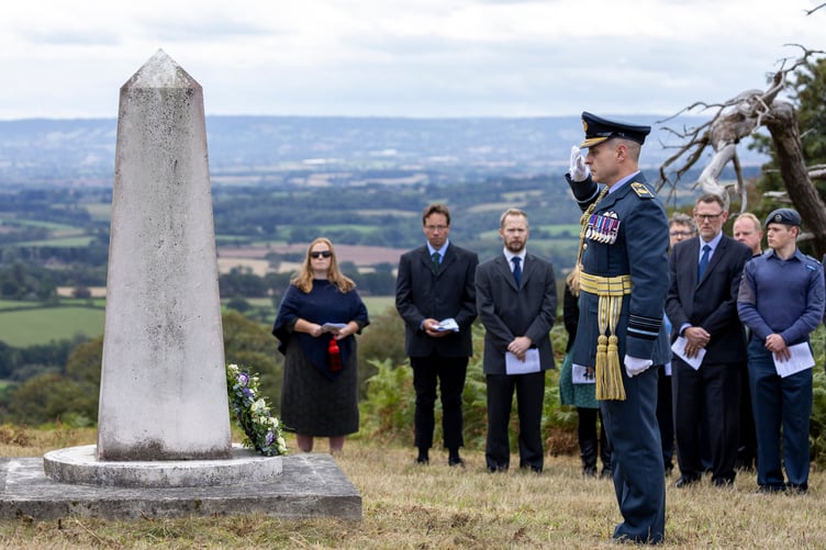 Air Marshal Mark Flewin, Air and Space Commander RAF, salutes a memorial on the Quantock Hills for nine RAF crew killed in a 1945 crash.