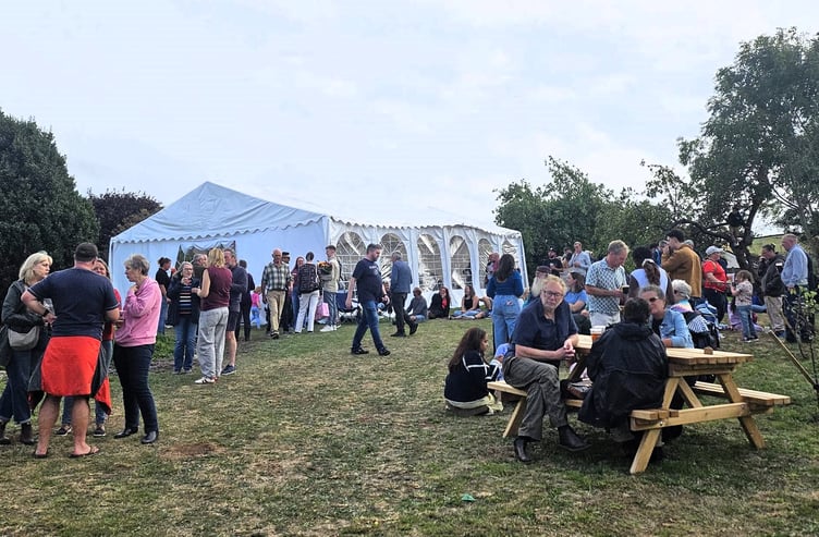 Cramptonbury Musicians' Festival goers take a break outside the Orchard Stage. PHOTO: Helen Moore.