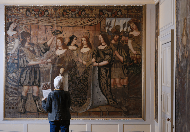 A visitor is dwarfed by one of Dunster Castle's leather hangings. PHOTO: National Trust/Steve Haywood.
